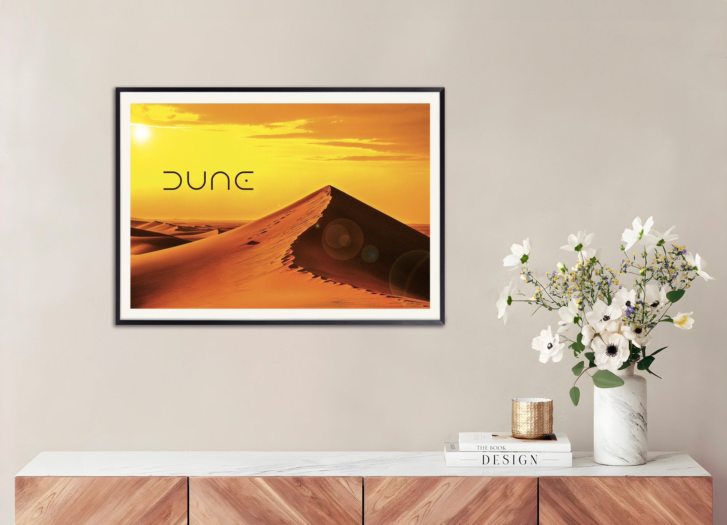 Framed 'Dune' poster on a wall above a wooden console table with decor items.