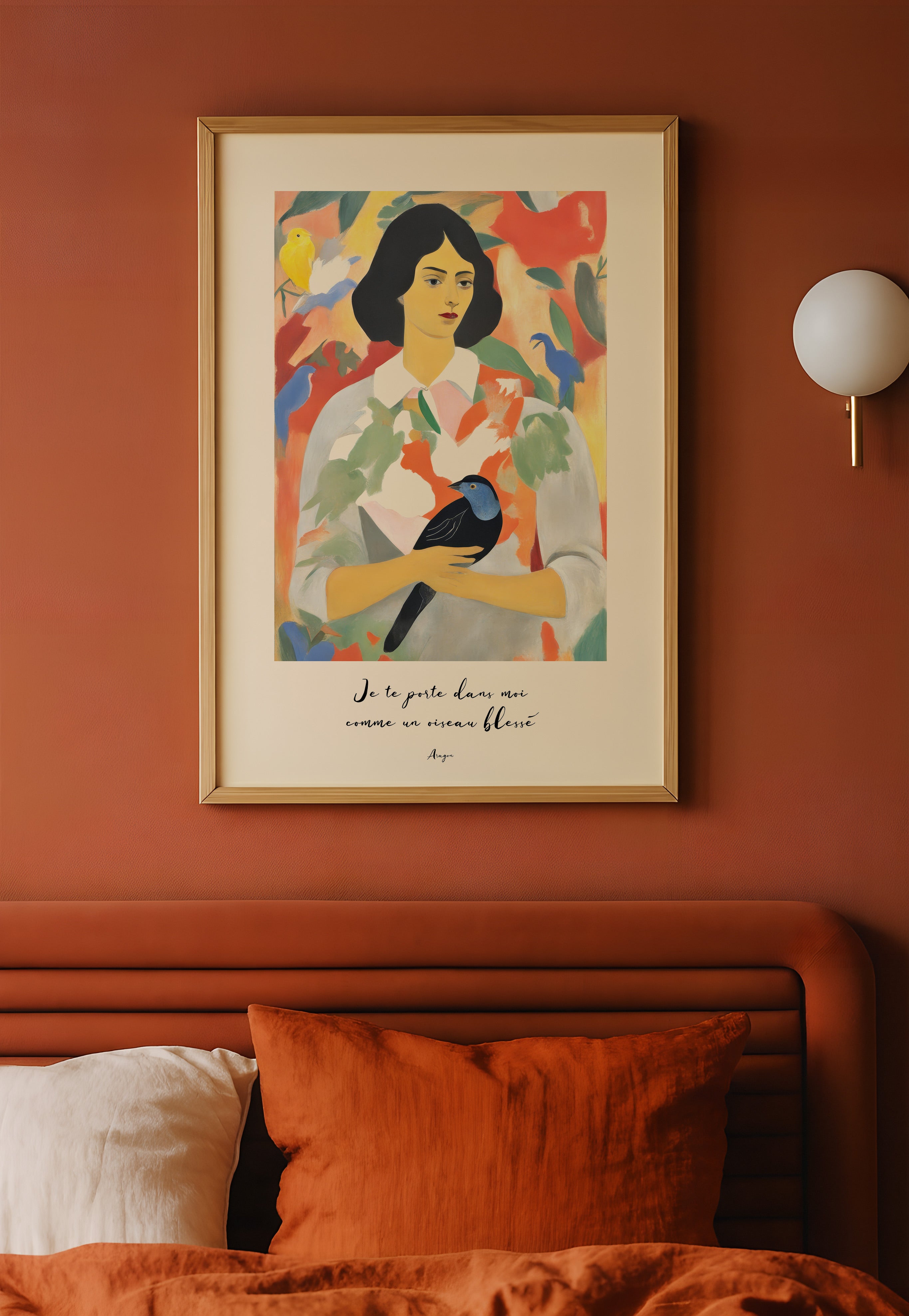 Framed colorful art print of a woman on an orange wall above a bed.