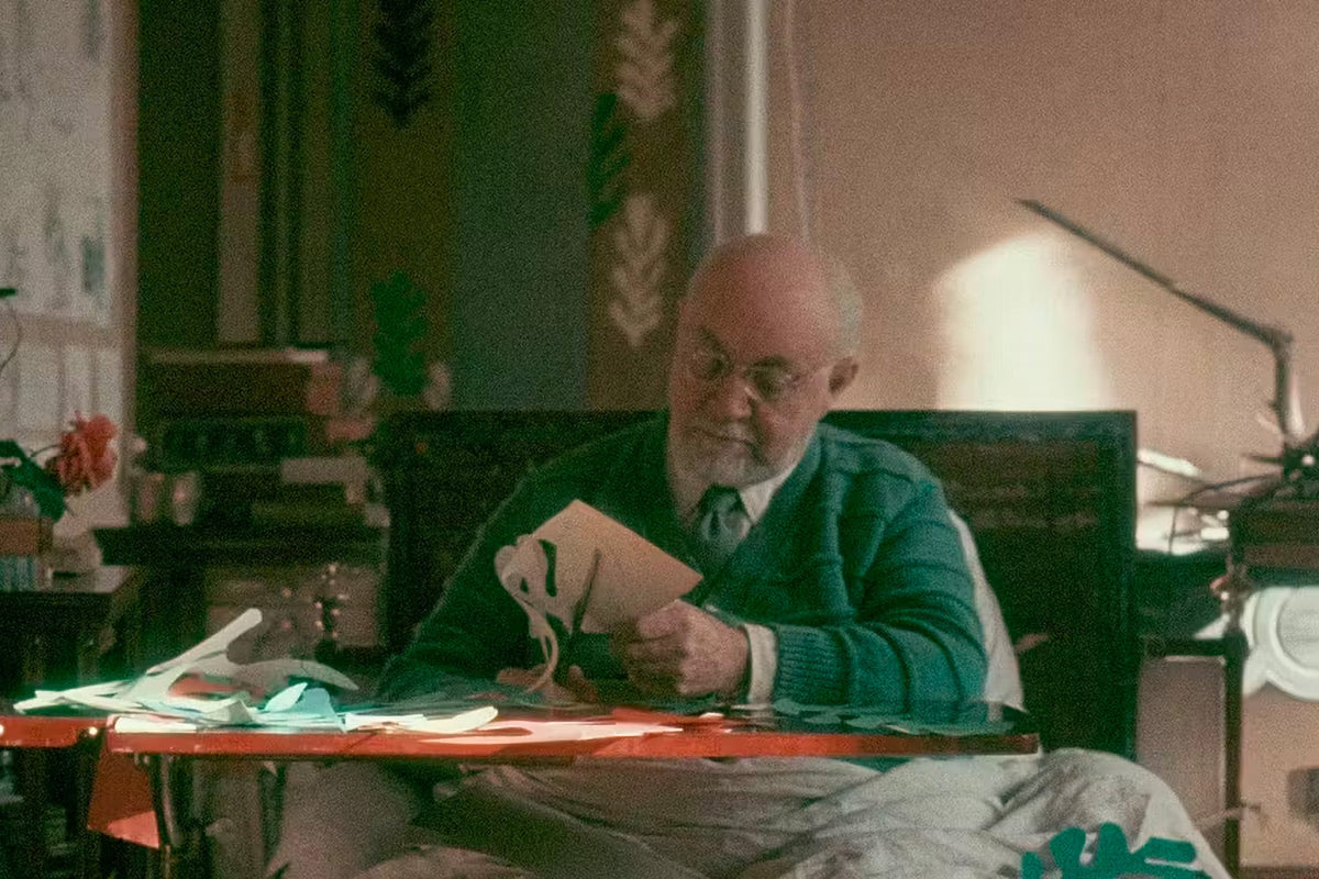 Henri Matisse en sus últimos años, recortando formas de papel pintado sentado a su mesa