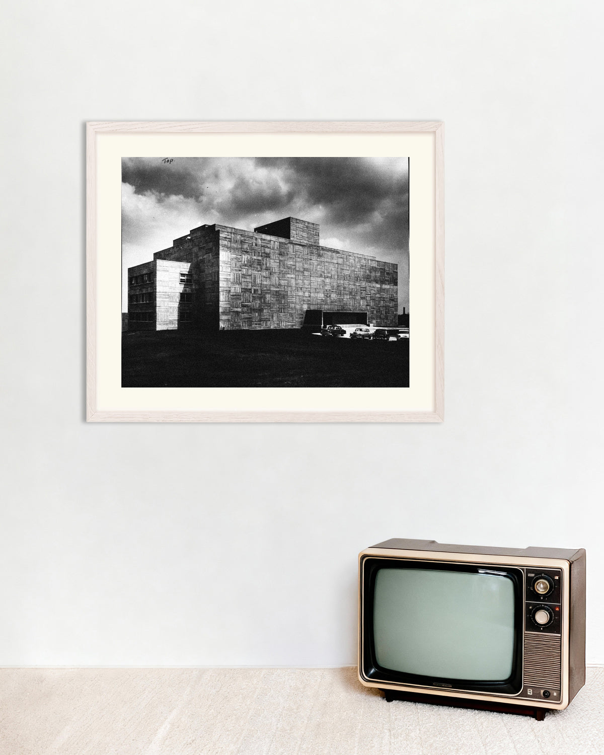 Póster «Edificio de hormigón bajo la tormenta», con marco de madera blanca